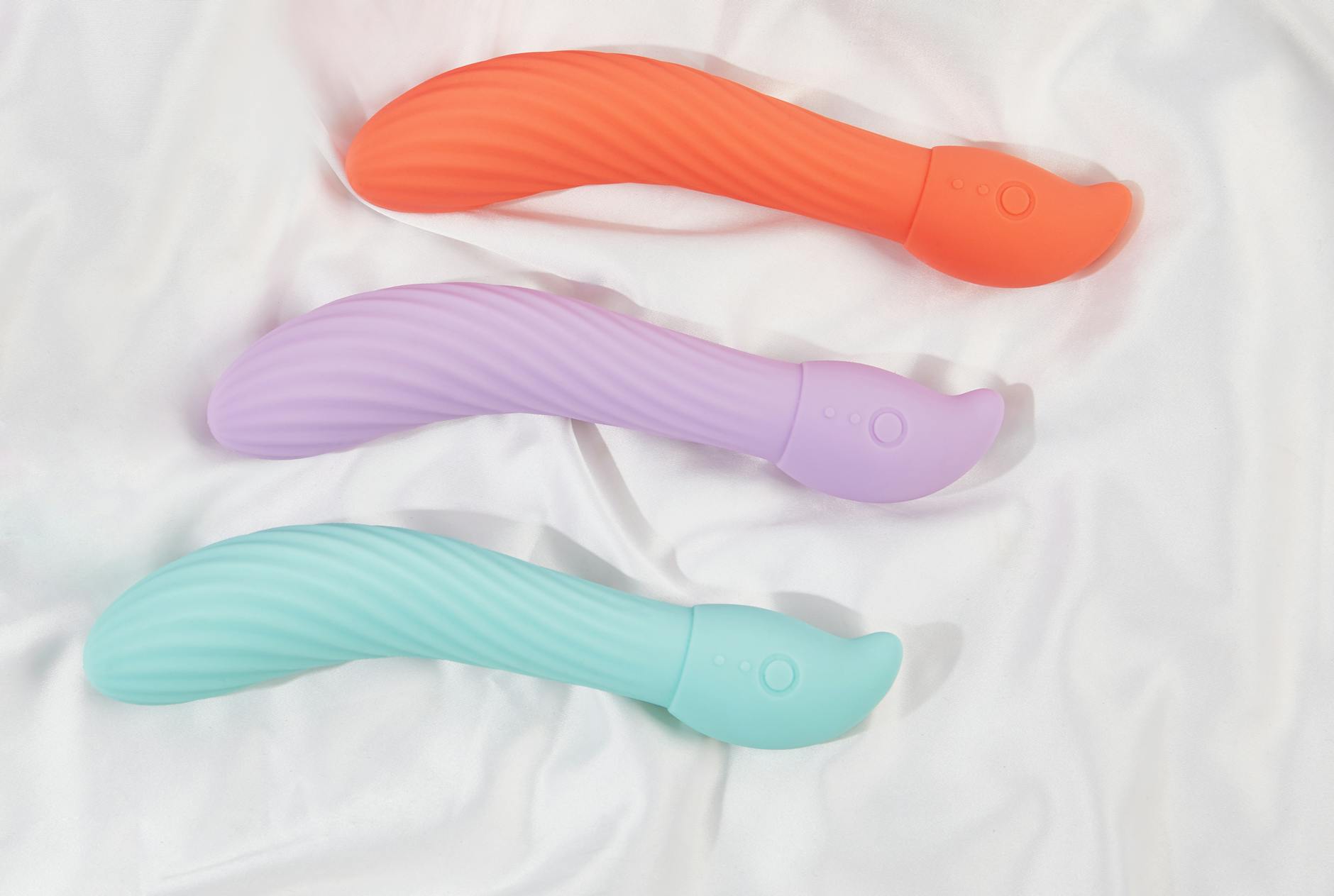 A teal lemon vibrator resting on smooth white silk fabric