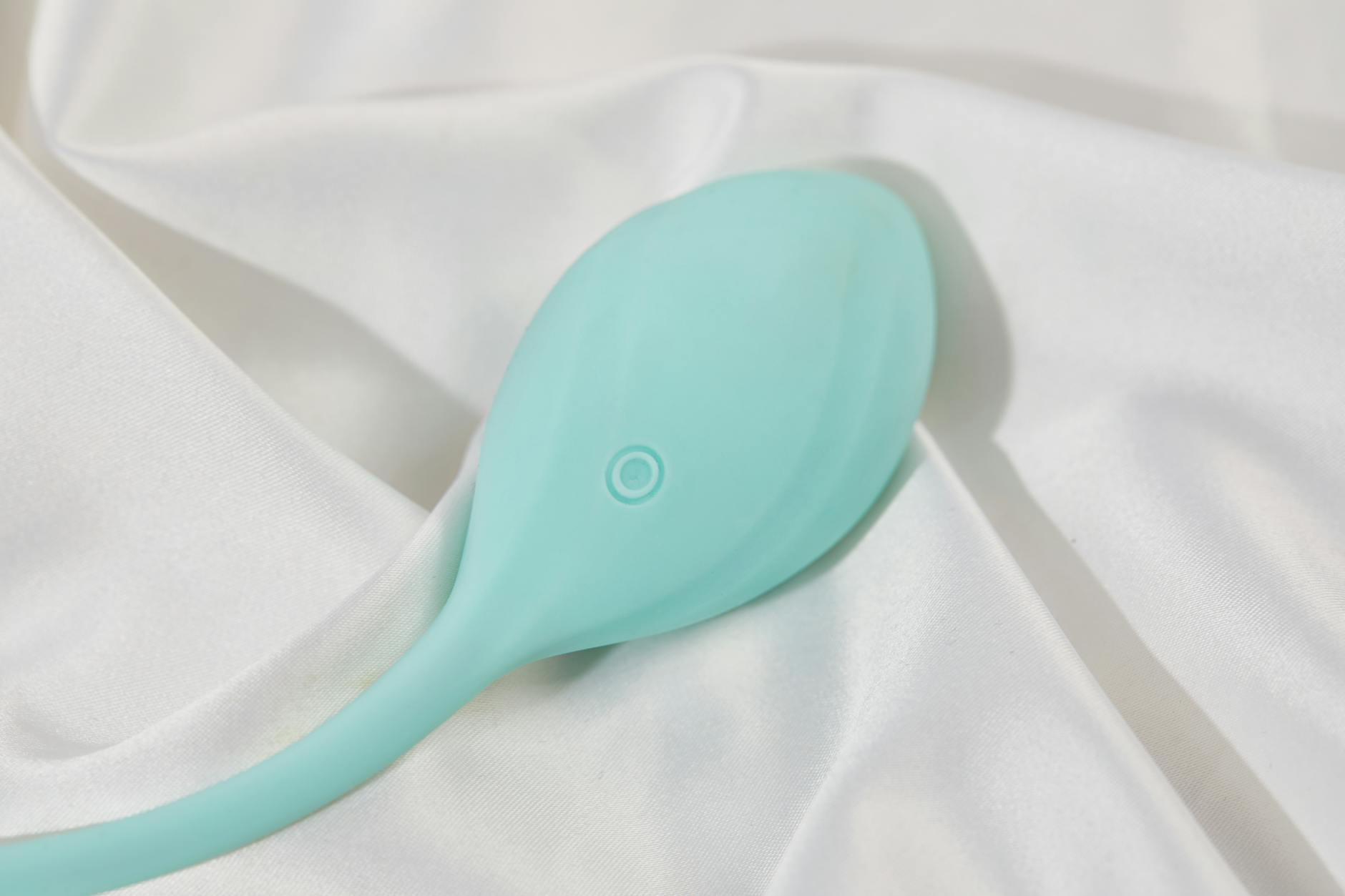 Woman holding blue and pink silicone vibrators in contemplative expression
