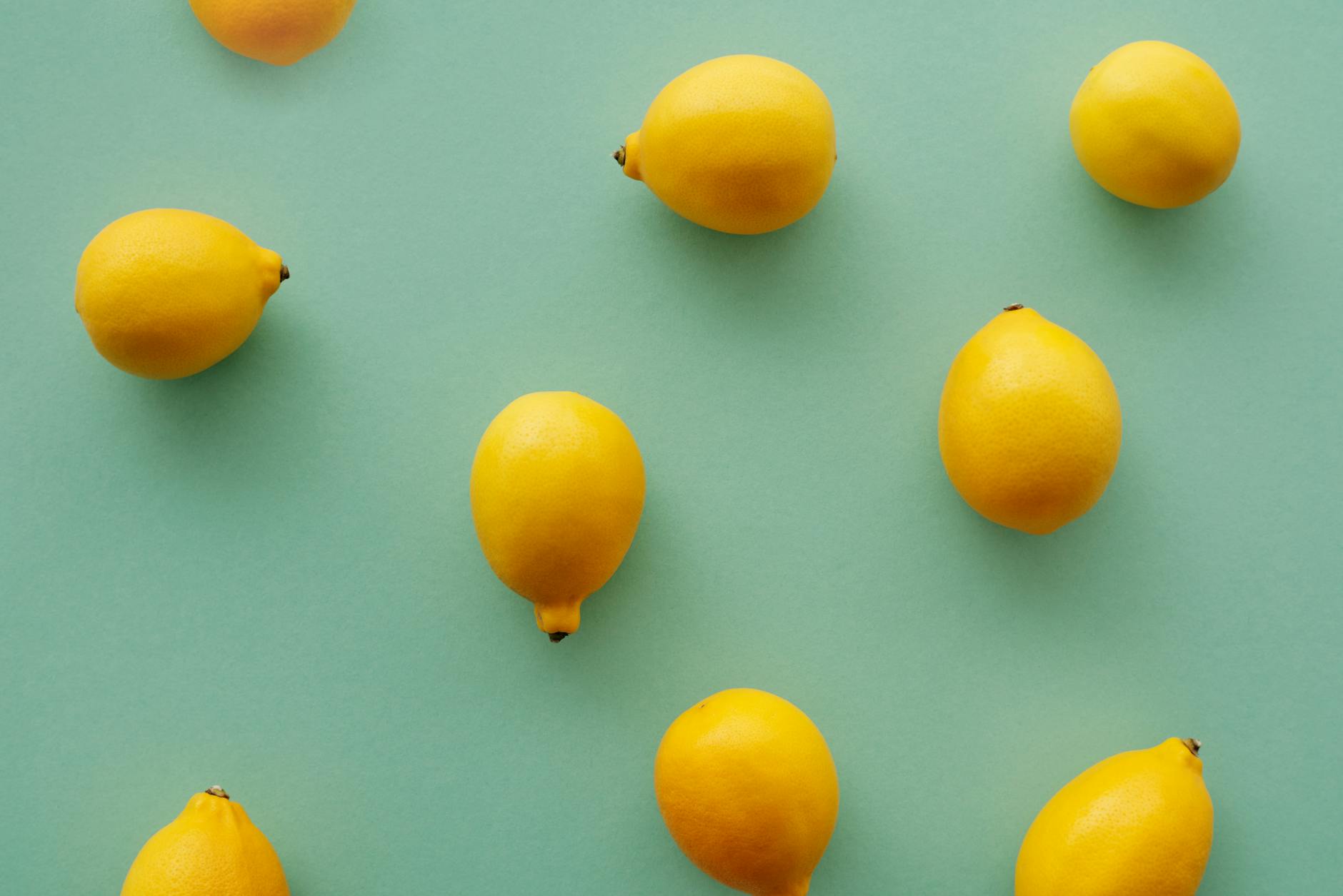Bright yellow lemons arranged on a pastel background, symbolizing the refreshing ease of lemon vibrators