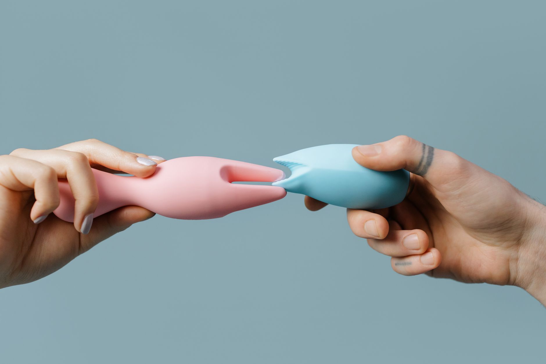 Person holding colorful silicone vibrators, comparing textures and designs