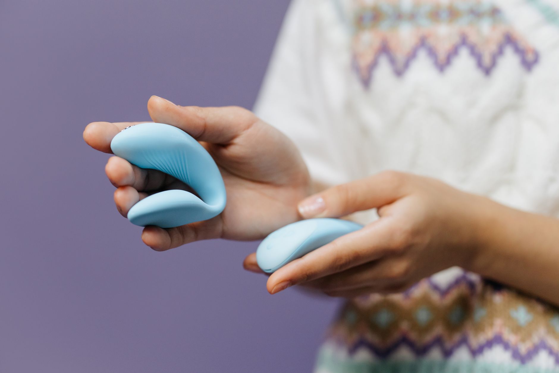 Woman holding blue silicone vibrator thoughtfully