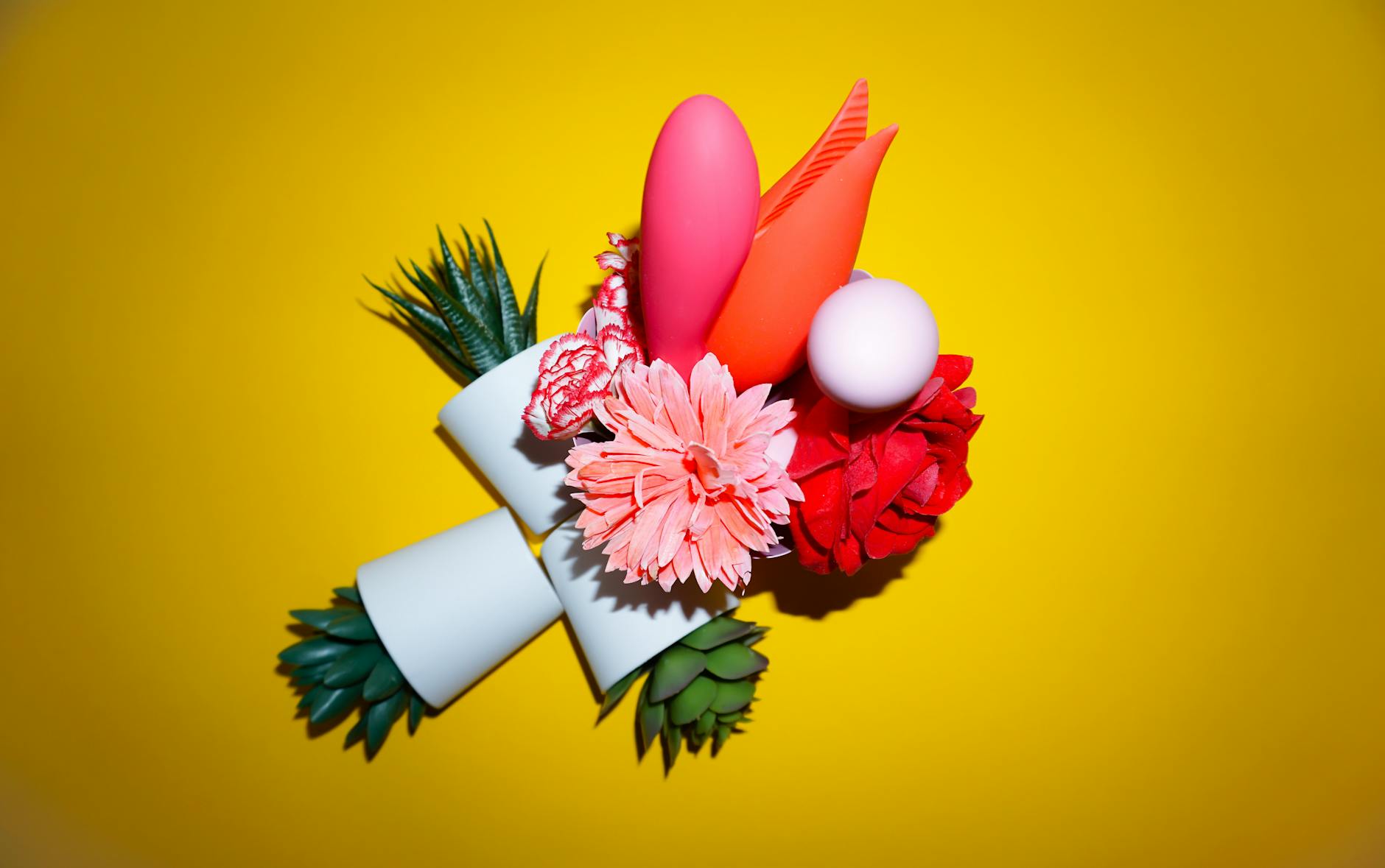 Hand holding a vibrant orange lemon vibrator against a minimalistic purple backdrop