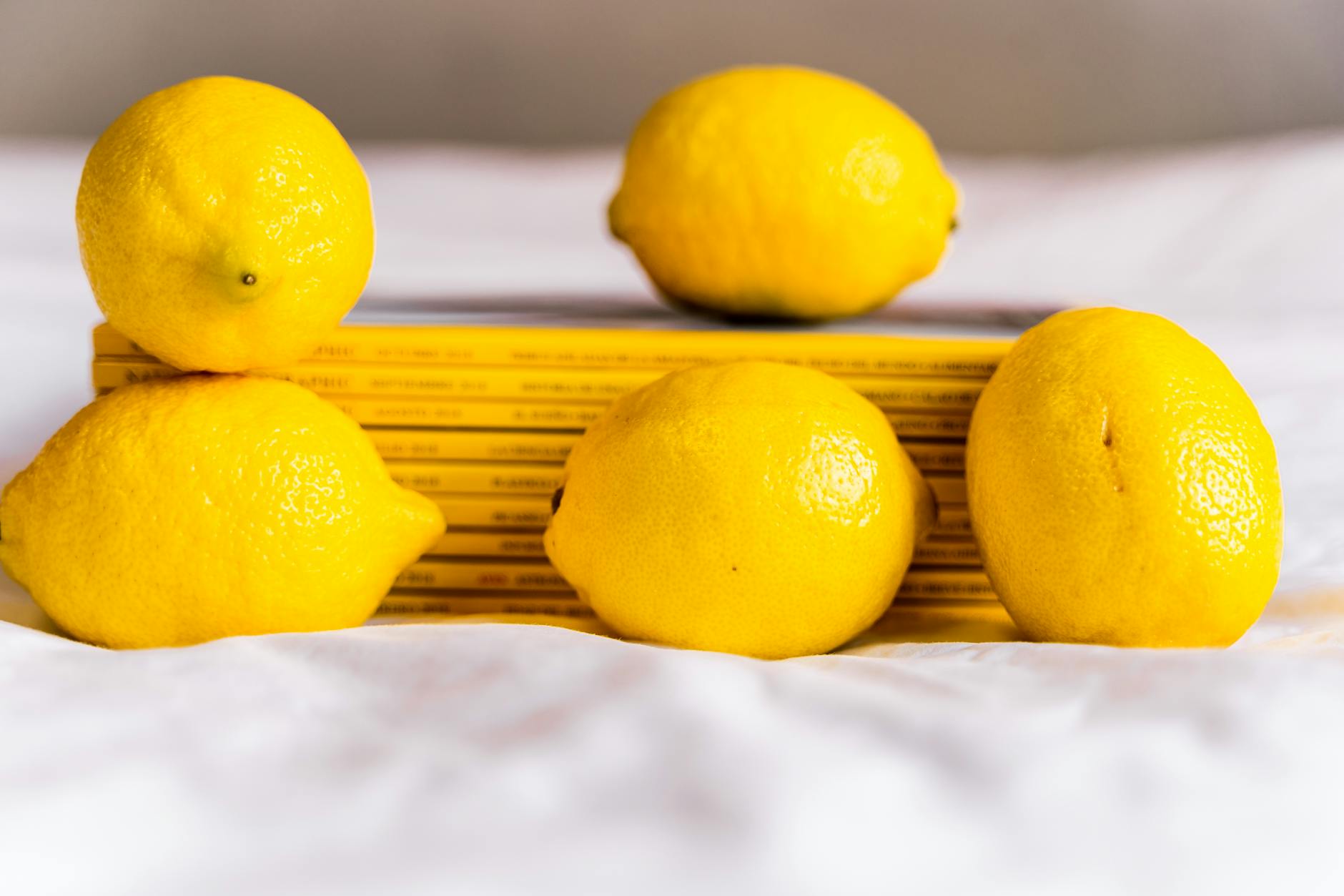 Ripe vivid lemons composed on yellow background in bright daylight
